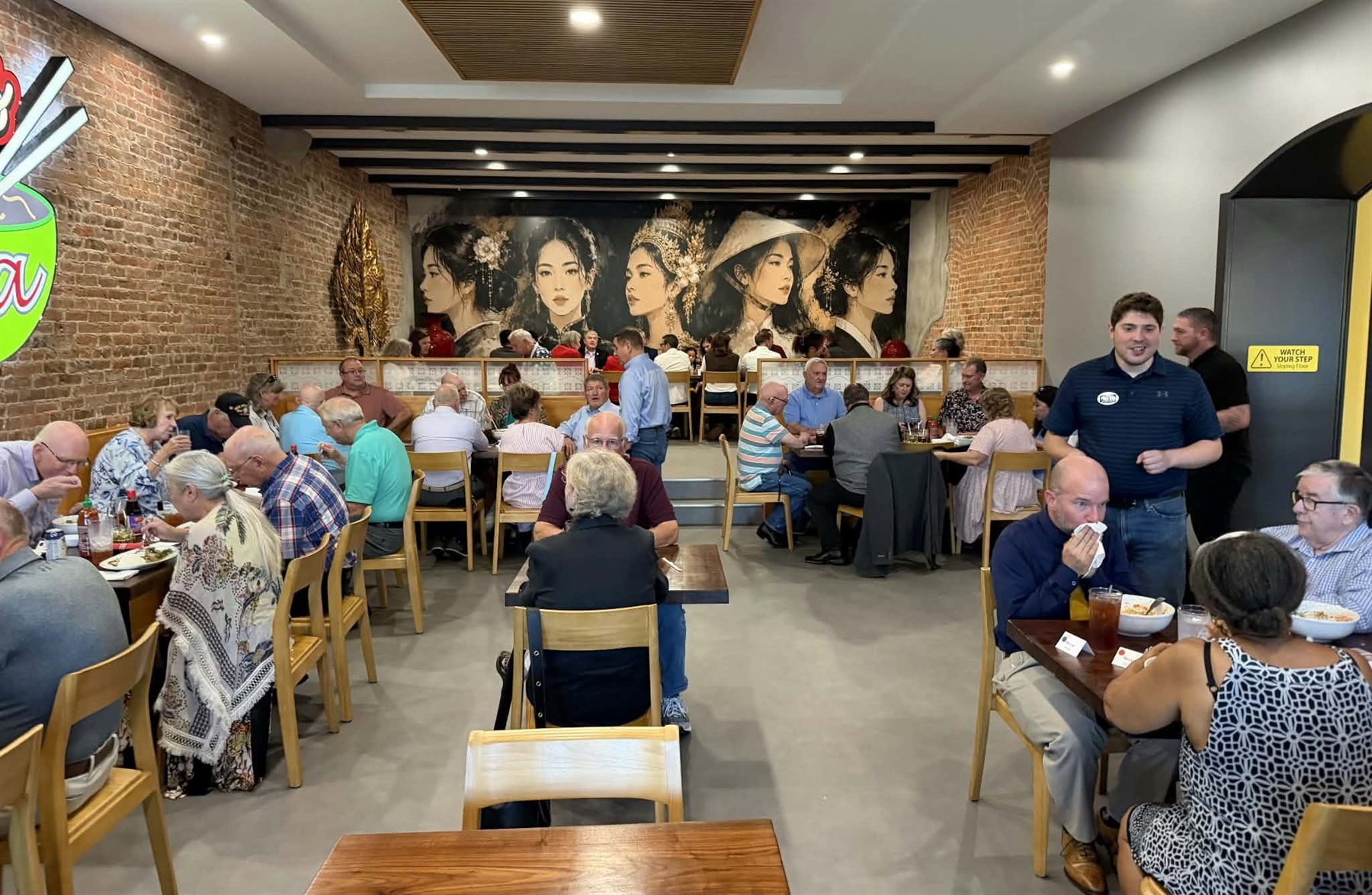 The dining room at Noodles of Asia, with the hand-painted mural along the back wall